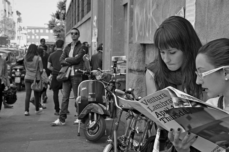 Two girls reading newspaper